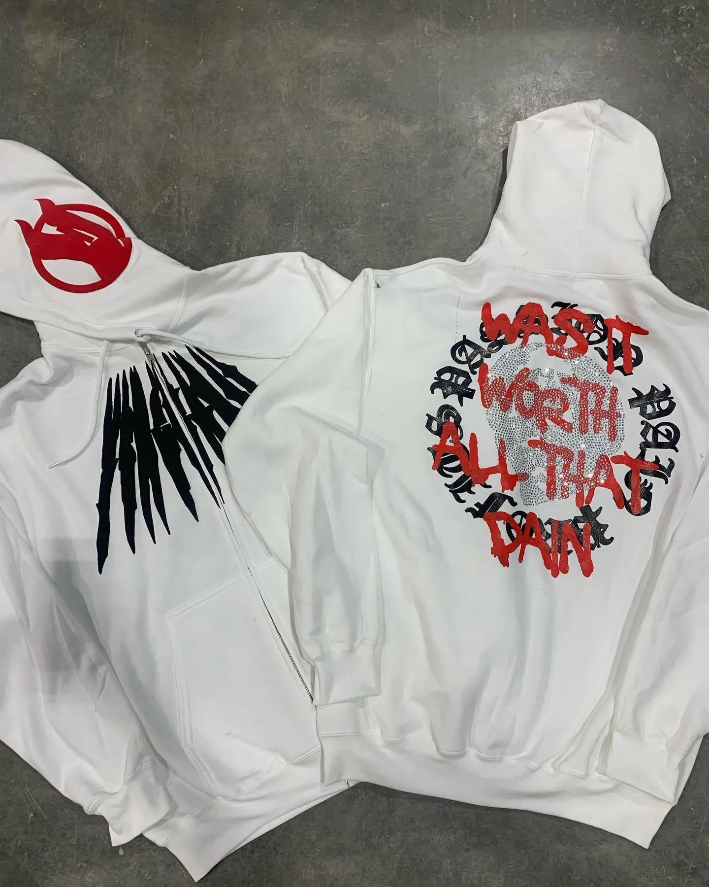 Black loose hooded sweatshirt with printed skull and rhinestone lettering on front