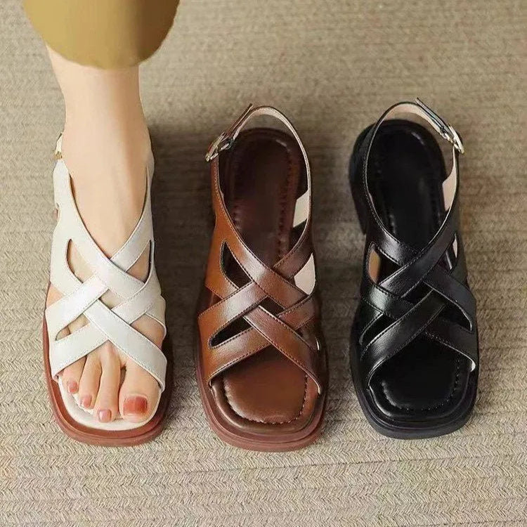 Women's glossy patent leather sandals with a square toe and flat low heel in black.