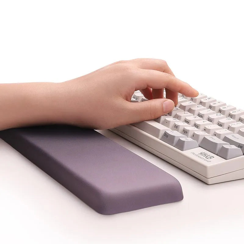 Square silicone wrist rest mouse pad with wrist strap in multiple colour options on a desk