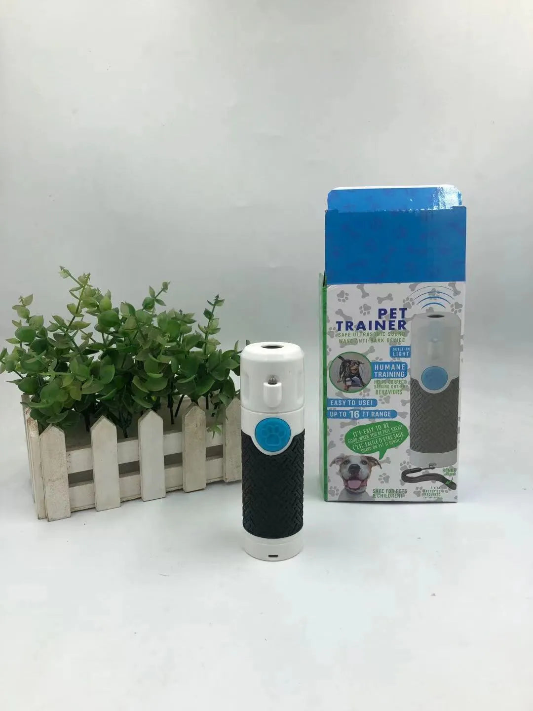 White handheld ultrasonic dog trainer bark stop device on a plain background.