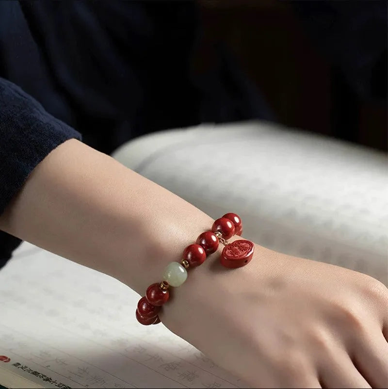 Natural cinnabar bracelet with Emperor sandstone design and Ping An Fu Lu motifs.