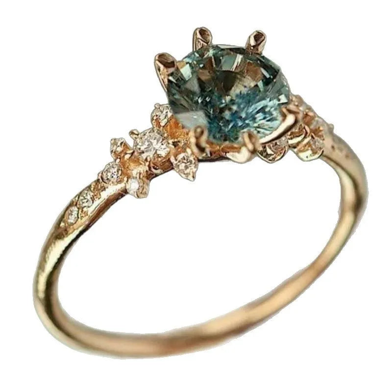 Gold geometric ring with chamfered square pattern and claw-set zircon stone