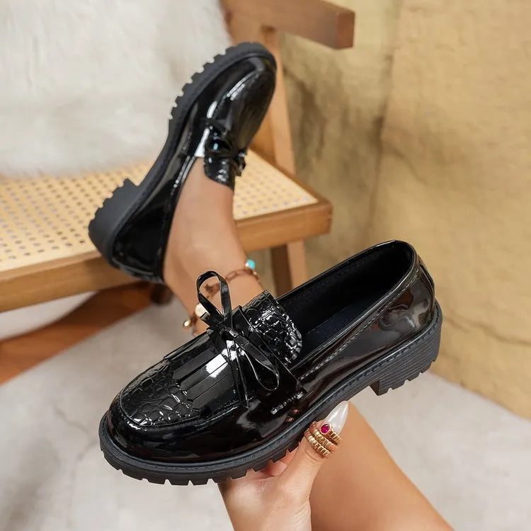 Women's black loafers with a decorative bow on the front, made from artificial PU.