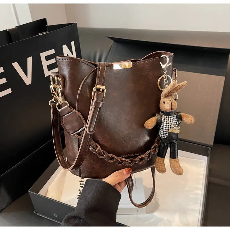 Women's retro bucket messenger bag in PU leather, 21x11x21 cm, with pendant detail and double shoulder strap connector