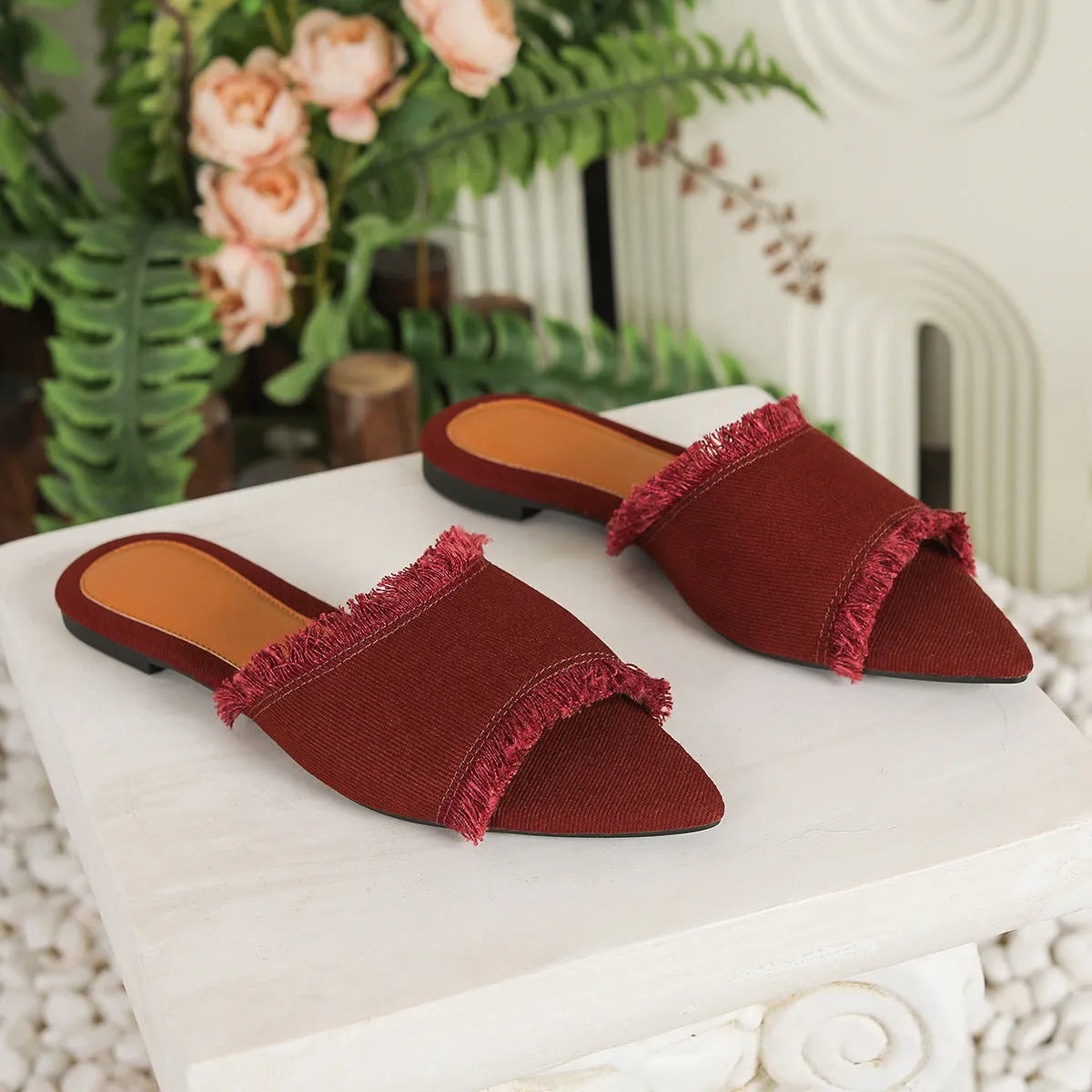 Women's denim flat slippers with a tassel, leather lining, and a PVC sole in various colours.
