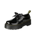 Women's black leather shoes with thick soles, cross straps, and ribbon lacing shown from side view