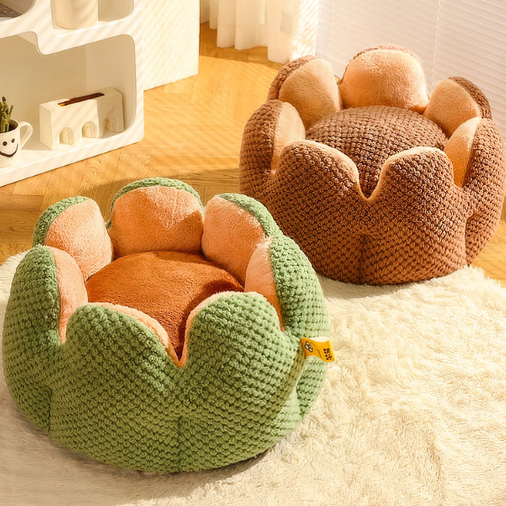 Green cactus petal shaped plush dog bed with a non-slip bottom on a wooden floor.