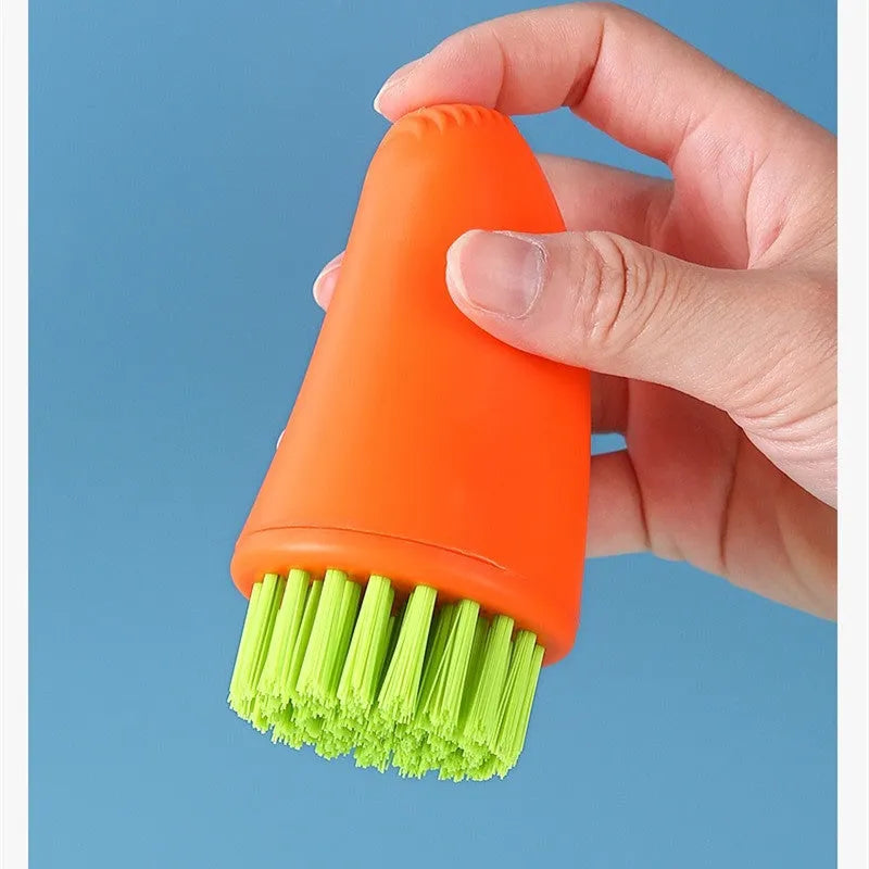 Orange and white carrot-shaped kitchen brush with nylon bristles for scrubbing.