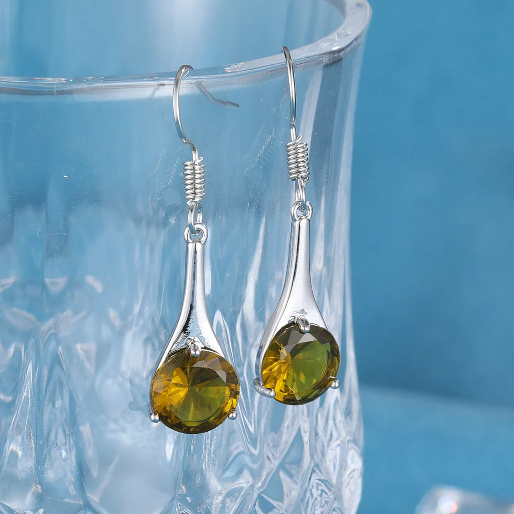 Olive green topaz coloured alloy drop earrings in a water drop shape on a white background.