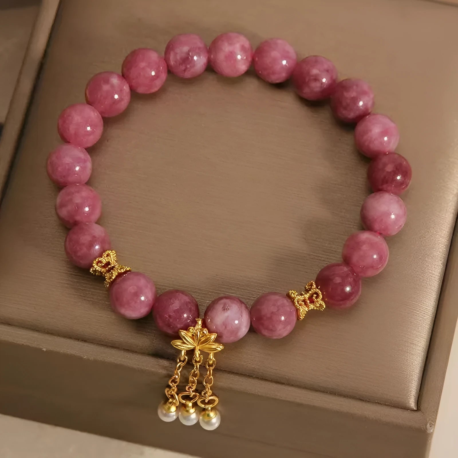 Pink and white natural stone bracelet with lotus flower pendant and tassel.