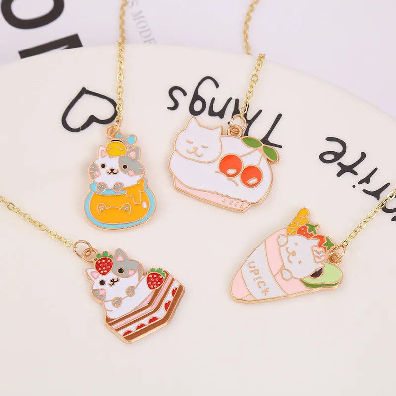 Metal cartoon cat bookmark with food-themed designs including strawberry cake and fruit roll styles