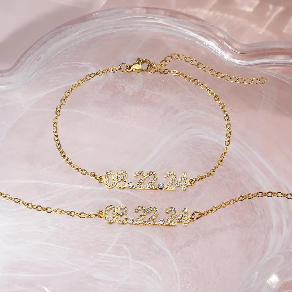 Stainless steel digital bracelet with crystal-set numbers on dial, shown in gold colour.
