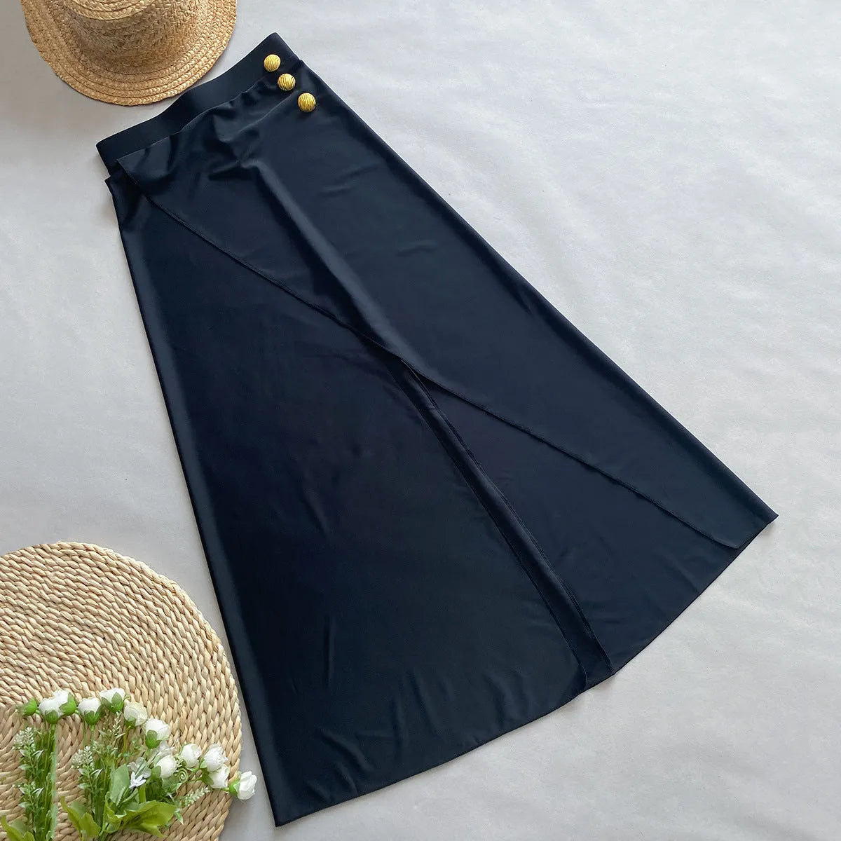 Women's brown one-piece swimsuit with matching beige skirt laid flat