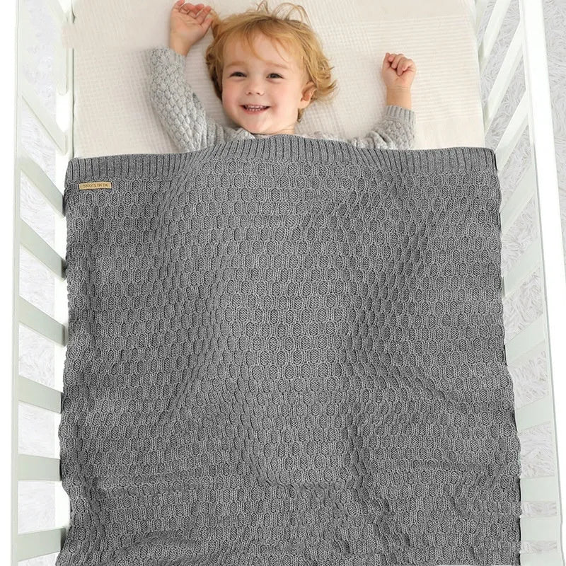 Solid colour acrylic infant hug blanket with textured lines, shown in beige khaki colour.