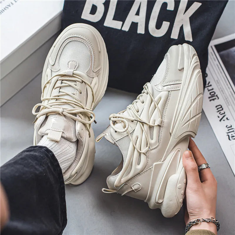 Men's beige and black low-top sneakers with mesh upper and rubber sole, showing lace-up front.